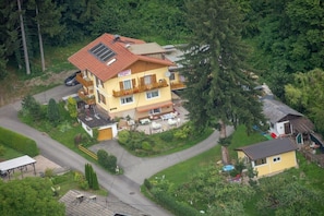 A two-story building with a balcony, a covered outdoor seating area, and a small adjacent structure. - Holiday apartment with 2 bedrooms (Bodensdorf)