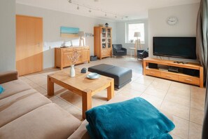 Ein modernes Wohnzimmer mit Sofa, Couchtisch, TV-Schrank und Schrank.