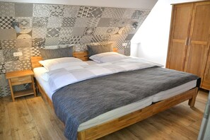 Ein Schlafzimmer mit einem hölzernen Bett, einer Wand mit Muster, einem Kleiderschrank und einem Nachttisch.