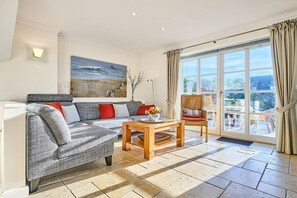 A living room with a sofa, a coffee table, and a painting on the wall. - Holiday home in Sylt with 3 bedrooms (Wenningstedt)