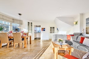 Un amplio espacio habitable con una mesa de comedor, sillas y un sofá.