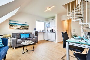 A modern apartment with a dining area, kitchen, and living room. - Holiday apartment with 2 bedrooms (Wenningstedt)