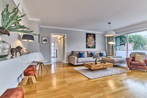 A modern living room with a sofa, coffee table, and a dining area. - Holiday apartment in Sylt with 3 bedrooms (Westerland)