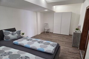 A bedroom with a bed, a chair, a wardrobe, and a small table with a plant. - Holiday apartment Hilmersdorf (Hilmersdorf)