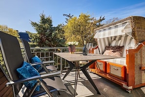An outdoor seating area with a table, chairs, and a wicker sofa. - Holiday apartment with 3 bedrooms (Westerland)