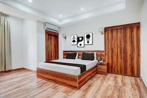 Un dormitorio moderno con un cabecero de madera, un armario grande y un aire acondicionado de pared.