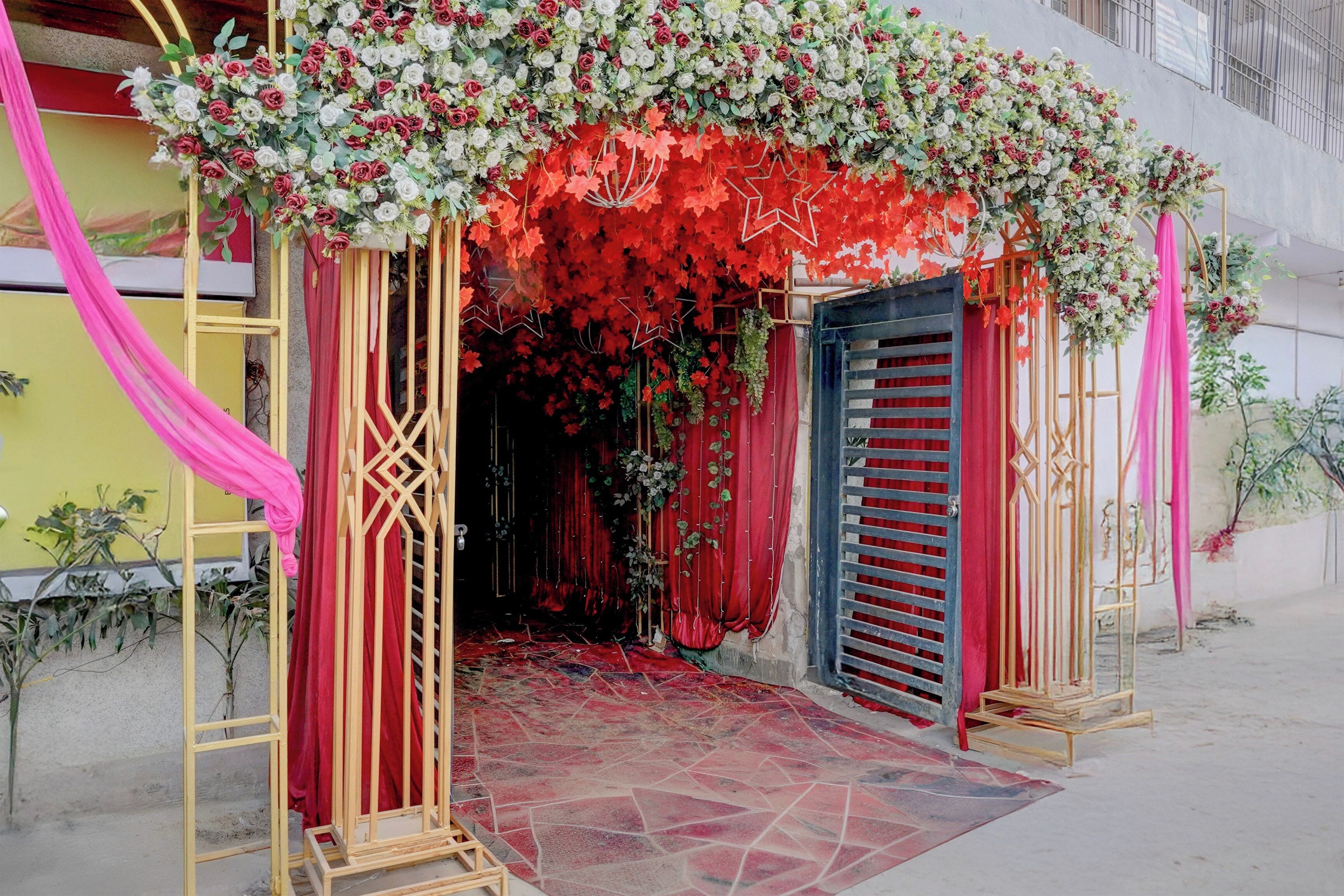 A doorway with a floral arch and red curtains.