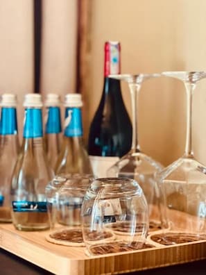 Un plateau en bois avec des bouteilles en verre transparent et des verres à vin.