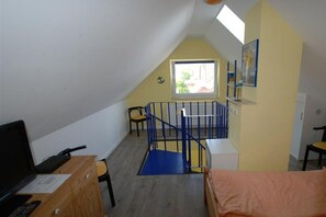 Ein Zimmer mit Schreibtisch, Stuhl, Bett und einem Fenster mit Blick.