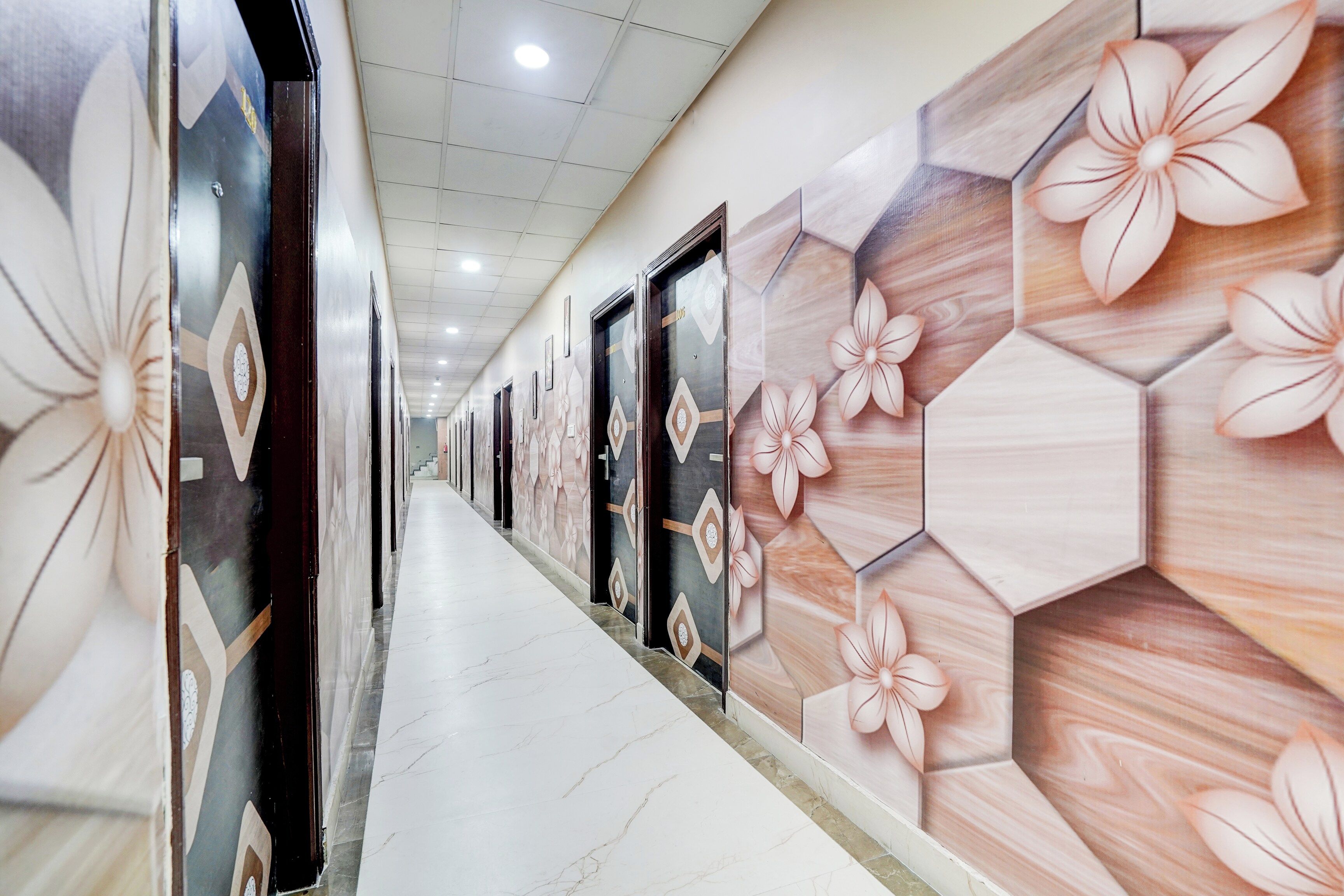 A corridor with patterned walls and doors, leading to a staircase.