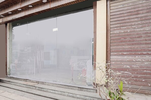 Un bâtiment doté d’une grande fenêtre en verre, d’une façade en bois et d’un escalier menant à l’entrée.