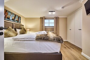 A bedroom with a bed, a painting, a window, and a wardrobe. - Holiday apartment with 1 bedroom (Rantum)