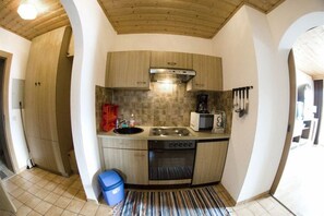 Een functionele keuken met een fornuis, oven en magnetron.
