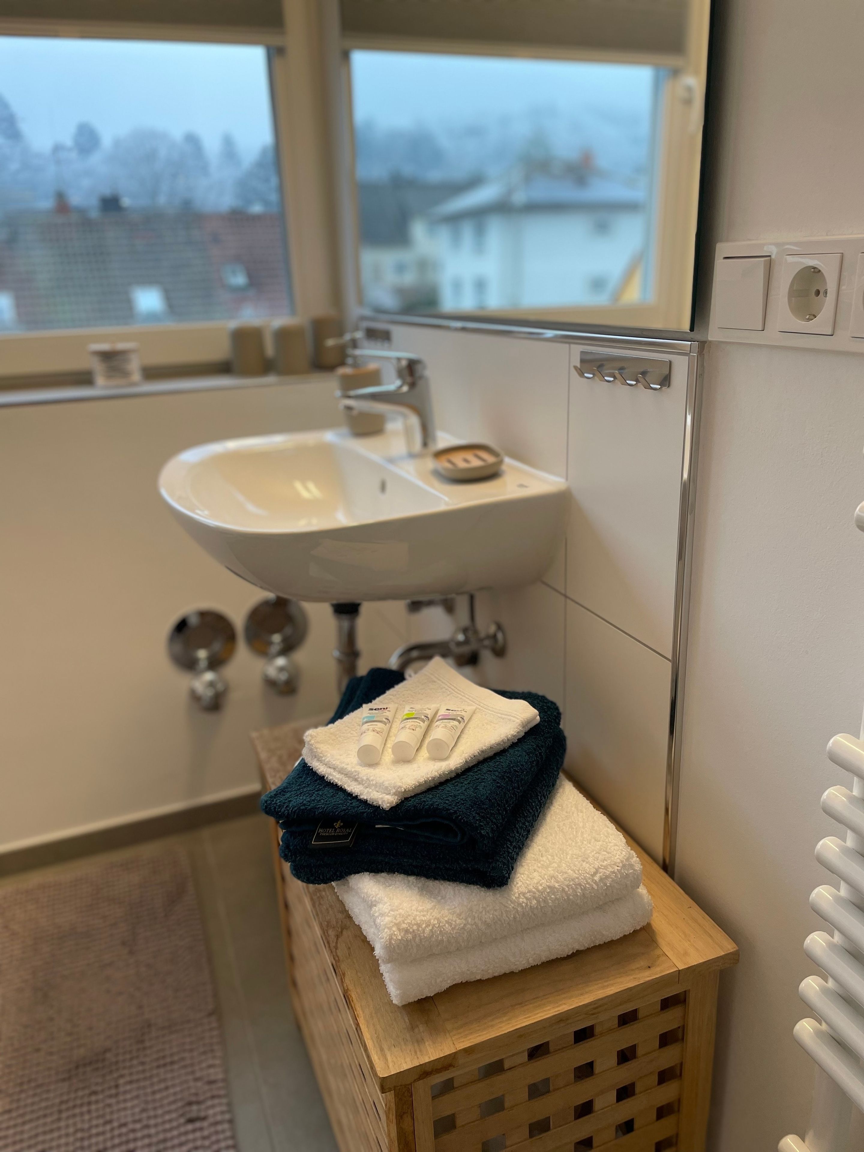 Une salle de bain équipée d’un lavabo, d’un miroir et d’un porte-serviettes.