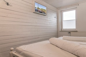 A bedroom with a bed, a window, and a picture on the wall. - 50111 Fisherman's Loft (Carolinensiel)