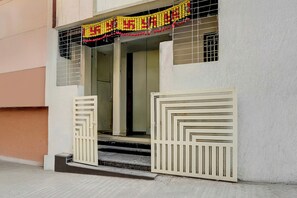 A building entrance with a set of double doors and a small set of steps leading up to the entrance.