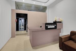 A reception desk with a sign that reads 'TOWNHOUSE Company-Serviced' and a flower arrangement on top.