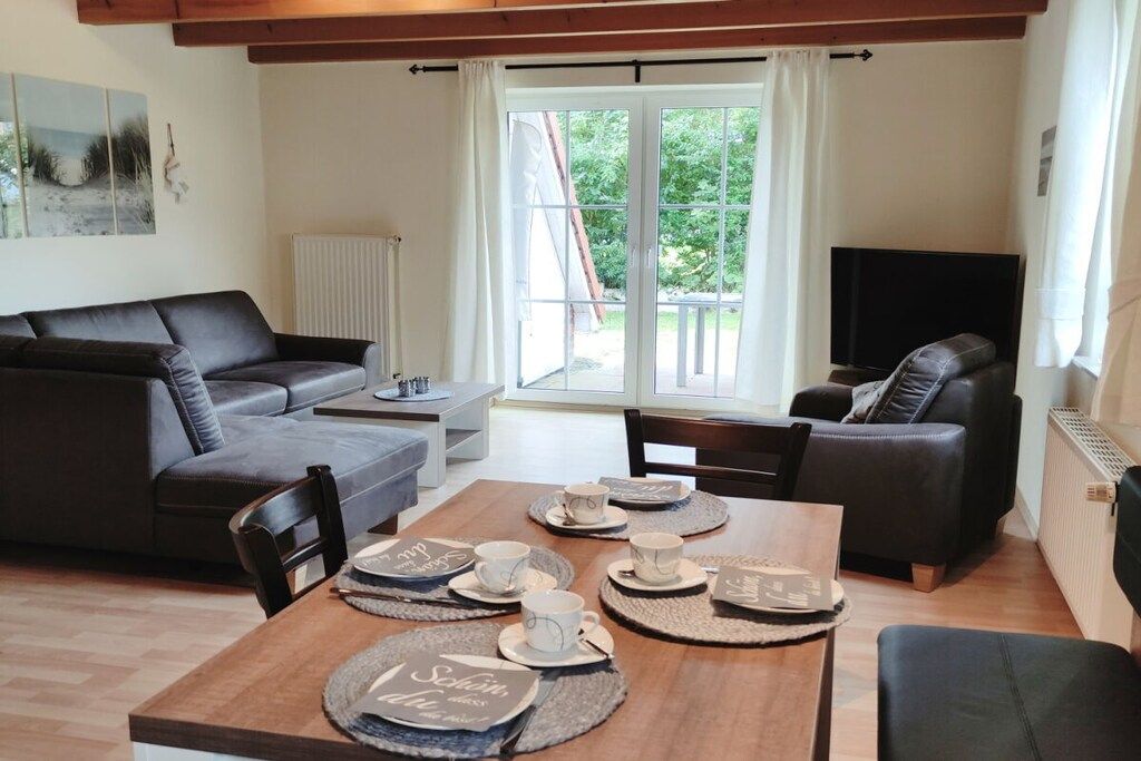 A modern living room with a sofa, a coffee table, and a TV.