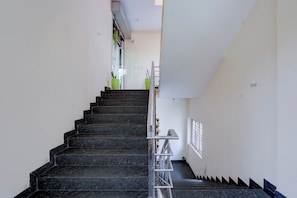 A staircase with a handrail, leading to an upper floor.