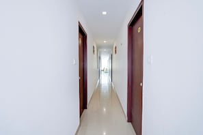 A long, narrow hallway with doors on both sides, leading to rooms.