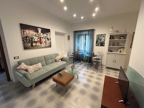 Un soggiorno con divano, tavolino e un quadro appeso al muro.