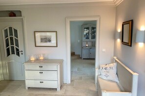 A hallway with a white dresser, a framed picture, and a cabinet with glass doors. - Holiday home in Kampen with swimming pool (Kampen)