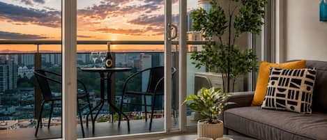 A modern living room with a balcony, a sofa, a coffee table, and a potted plant.