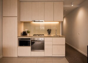Een moderne keuken met inbouwapparatuur, een aanrecht en een spatwand.