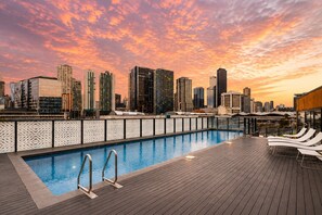 A rooftop pool with a city skyline view at sunset. - Docklands 2 Bedroom Hideaway (Docklands)