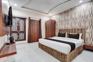 Habitación de hotel con cama, armario y televisor.
