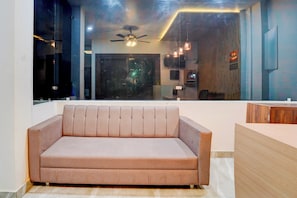 Una sala de estar moderna con un sofá, un ventilador de techo y vistas al exterior.
