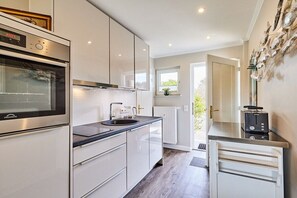 Eine moderne Küche mit Backofen, Spüle und Toaster auf der Arbeitsplatte.