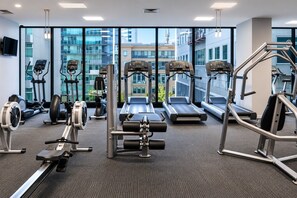 A gym with treadmills, elliptical machines, and weight equipment. - Flagstaff Park View 2 Bedroom (Melbourne)