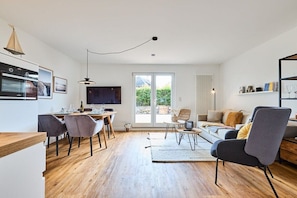A modern living space with a kitchen, dining area, and seating area. - Holiday apartment with 1 bedroom (Archsum)