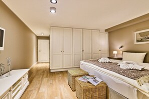 A bedroom with a bed, a wardrobe, a bedside table, a lamp, and a wall-mounted picture. - Holiday apartment with 2 bedrooms (Westerland)