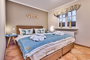 Un dormitorio con una cama, una mesita de noche, una ventana con cortinas y una decoración en la pared.