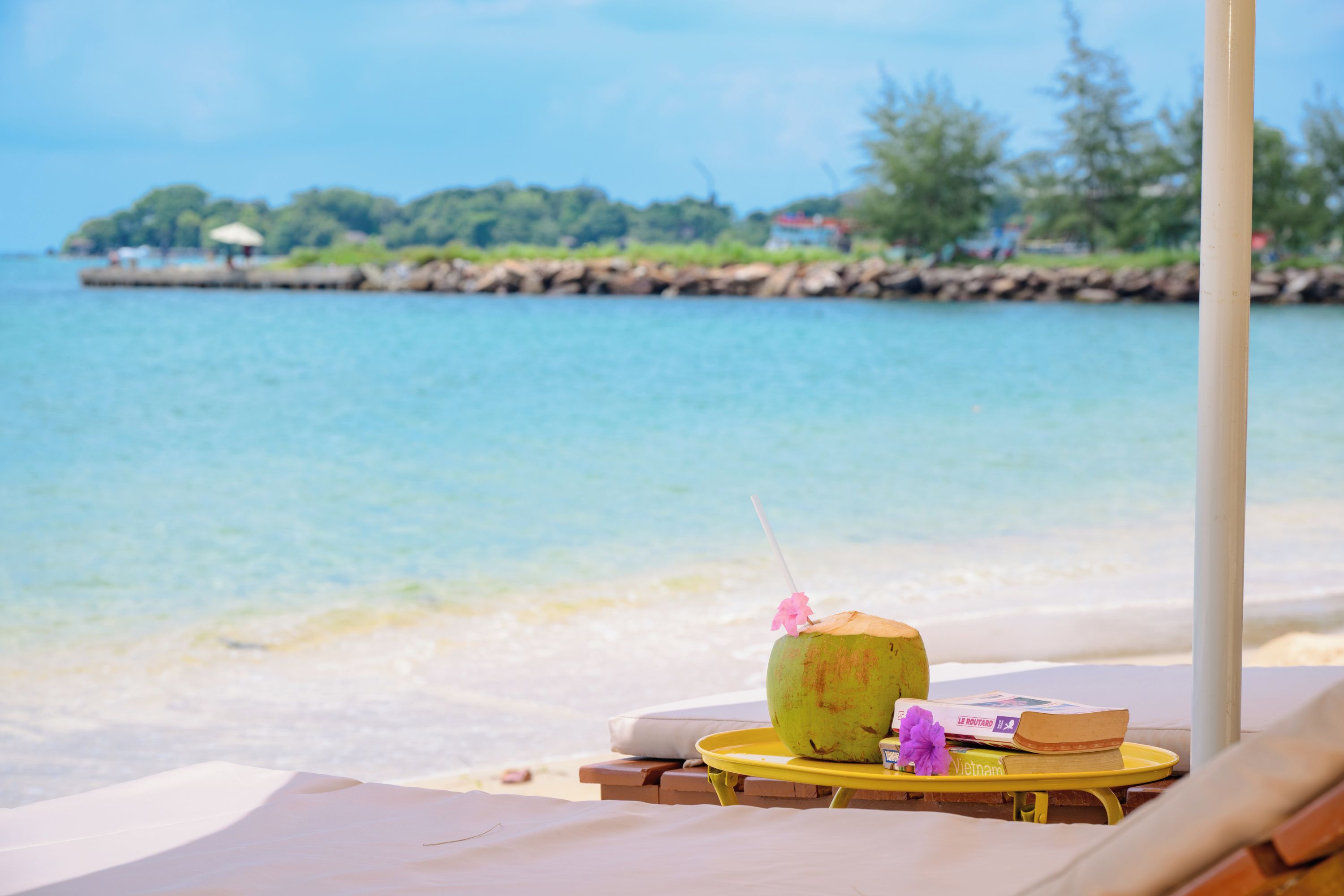 Un espacio de relax frente a la playa, con vistas al mar y una isla en la distancia.