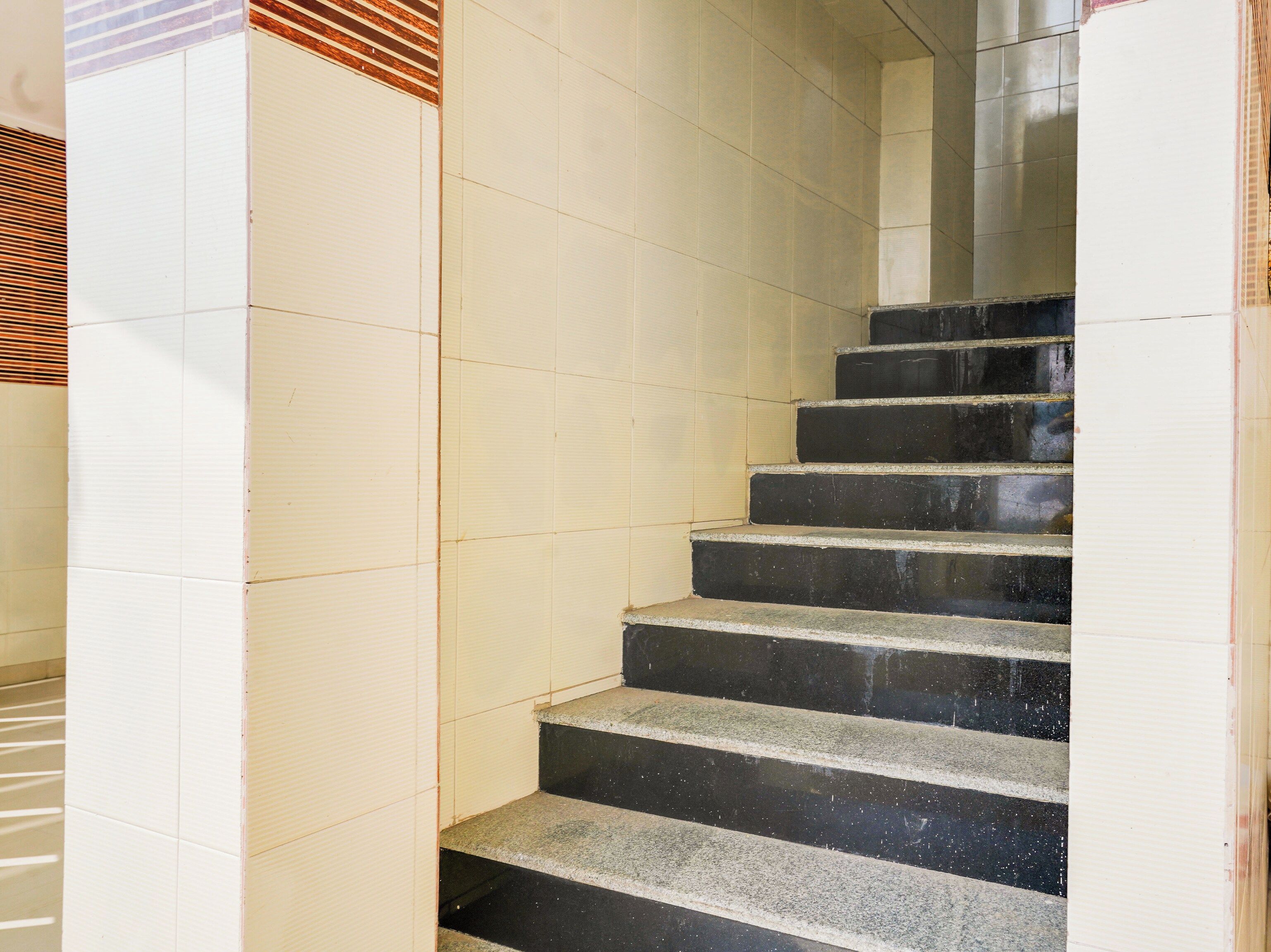 Una escalera con peldaños negros y paredes blancas.