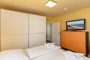 Une chambre d’hôtel avec un lit, une télévision et une armoire.