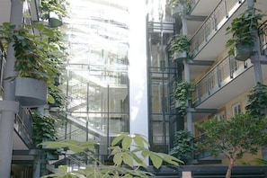 A multi-level atrium with vertical gardens and a glass elevator shaft. - Holiday apartment Haus Meeresblick 319636 (Kühlungsborn - West)