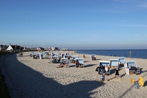 A beach with rows of beach chairs and umbrellas, a clear sky, and the ocean in the background. - Holiday apartment with 1 bedroom (Hörnum \/ Sylt)