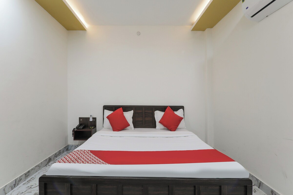 Una habitación de hotel con cama, mesita de noche y mesilla.
