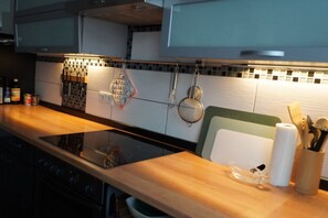 A kitchen with a wooden countertop, a built-in stove, and a backsplash with a mosaic tile pattern. - Holiday home in Schweich with swimming pool (Schweich)