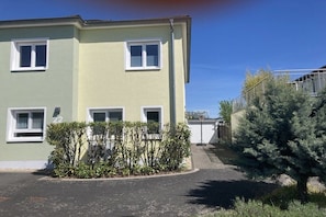 A two-story building with a flat roof, multiple windows, and a paved driveway. - Holiday home in Schweich with swimming pool (Schweich)