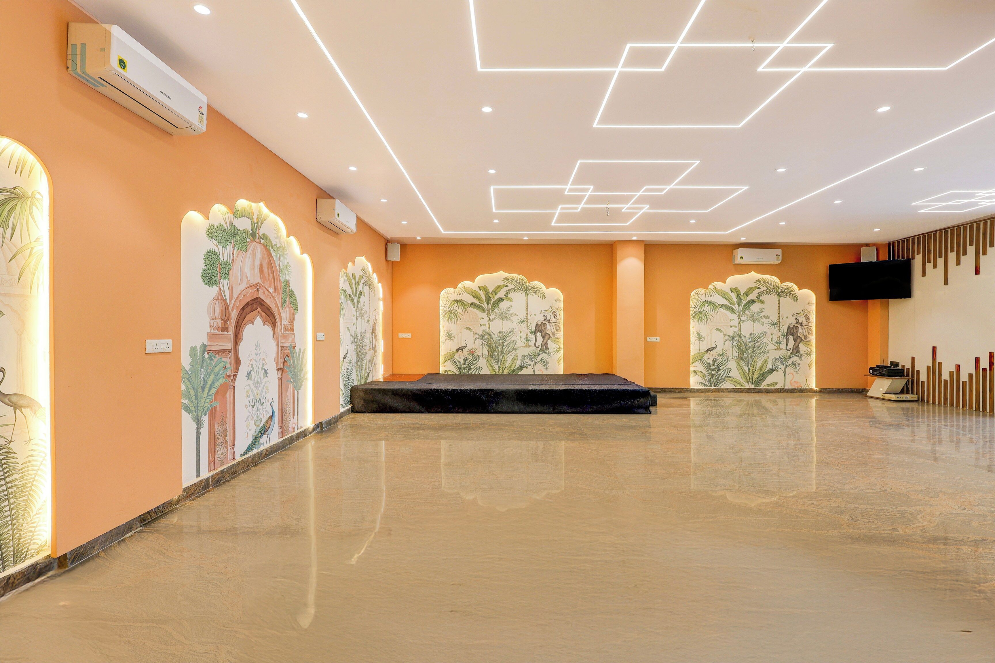 A spacious indoor area with a polished floor, decorative wall murals, and recessed ceiling lighting.