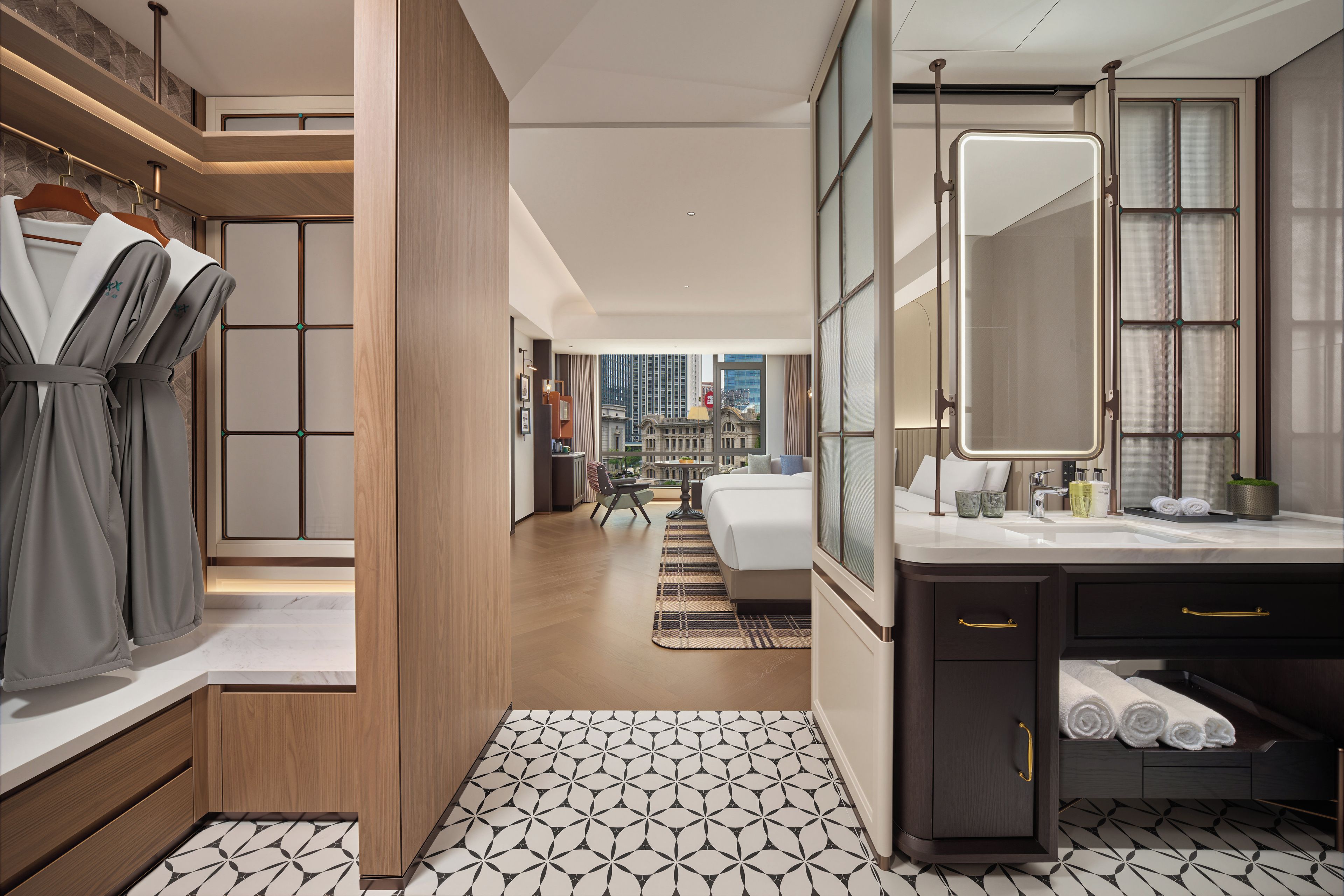 Une chambre d’hôtel moderne dotée d’un grand lit, d’une salle de bain avec un miroir et un lavabo, et offrant une vue sur le paysage urbain.