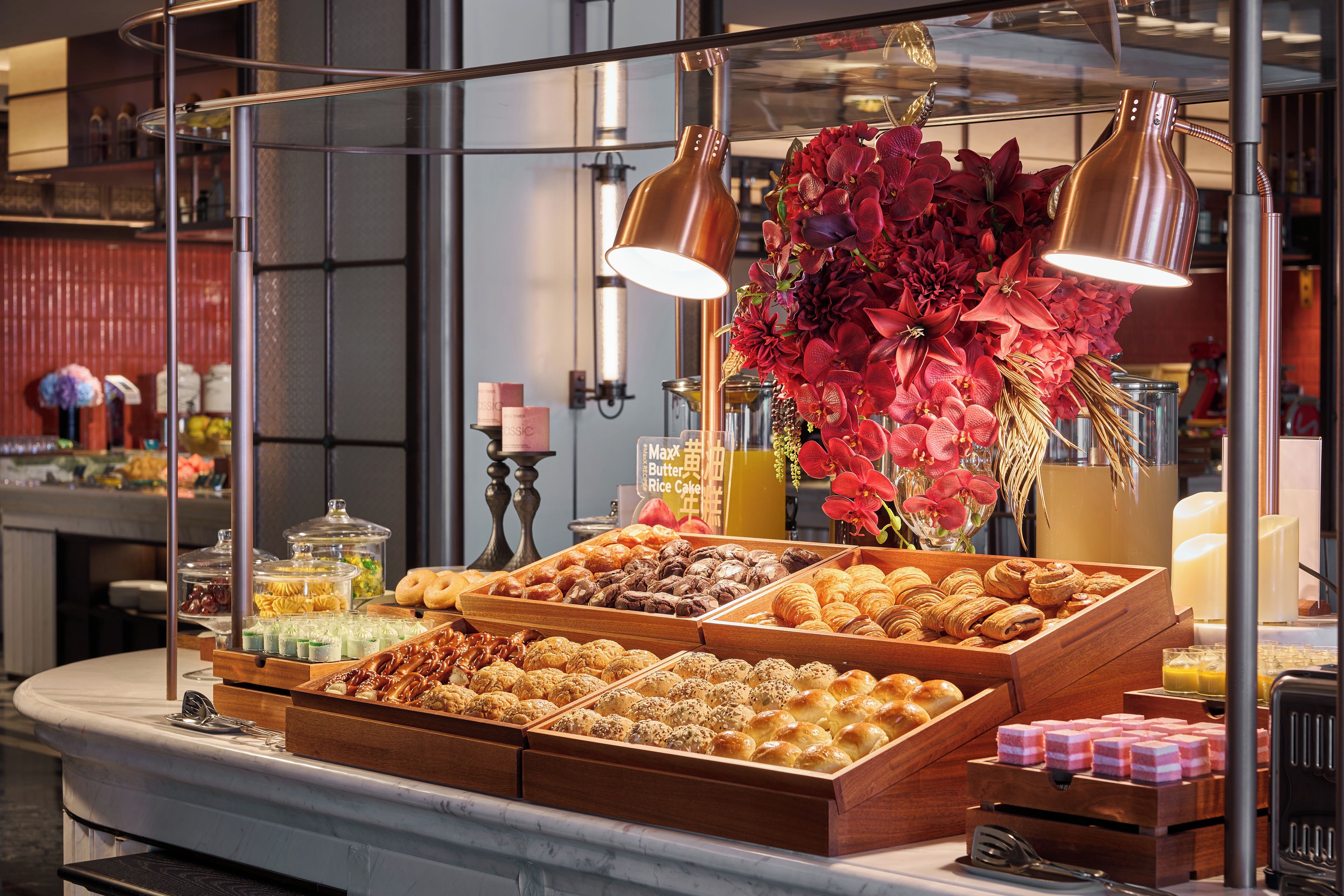 A bakery display with various baked goods and a floral arrangement.