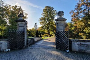 A paved pathway leading to a gated entrance with two ornate stone pillars. - Holiday apartment with 1 bedroom (Ostbevern)