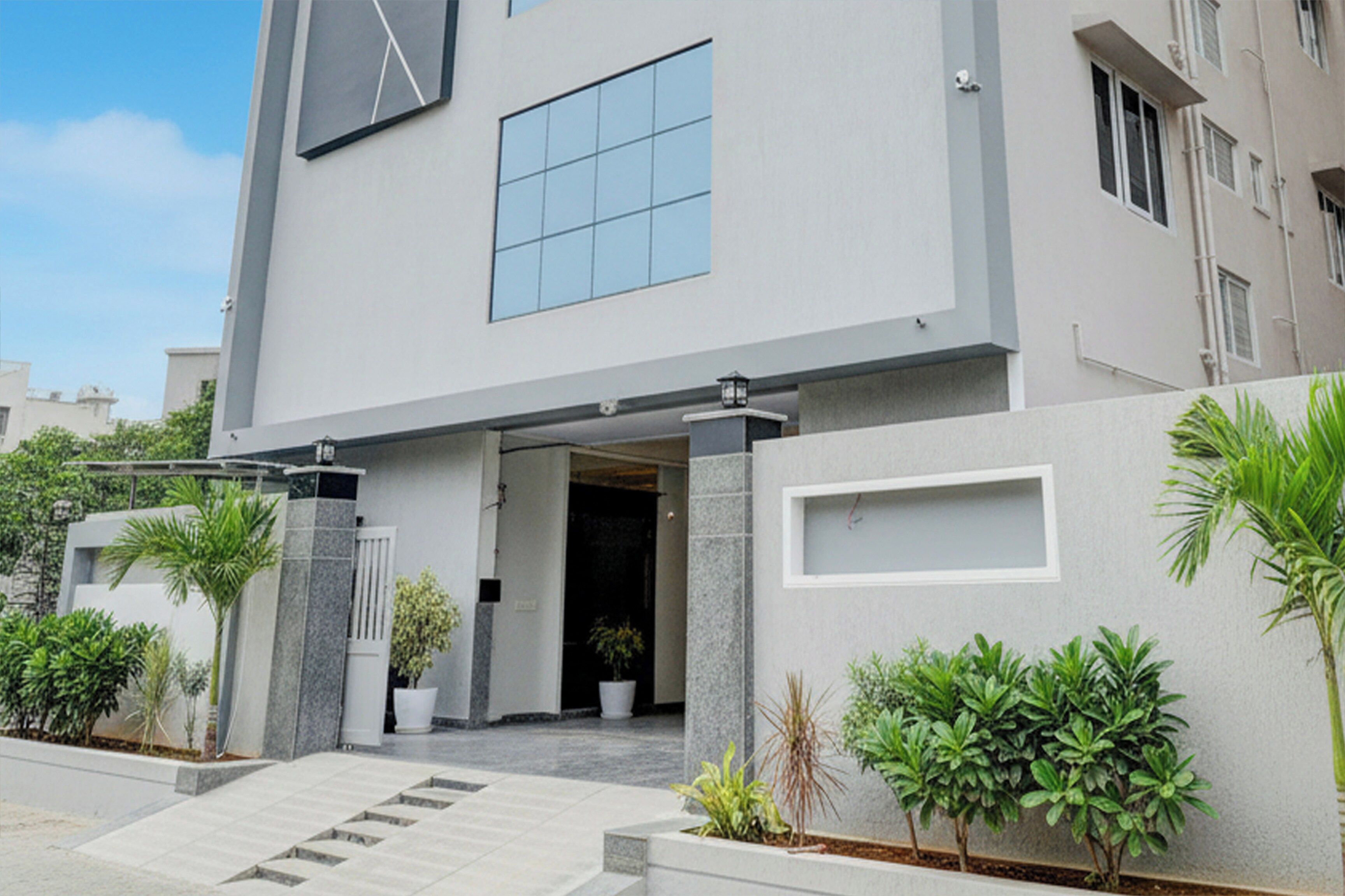 A modern building with a flat roof, large windows, and a clean entrance.