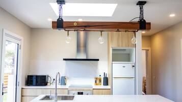 A modern kitchen with a central island, stainless steel appliances, and pendant lighting.